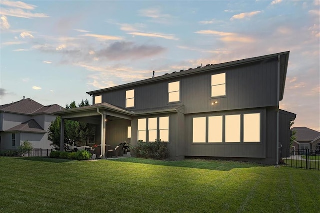 1220 Kingsland Cir, Raymore, MO 64083 - back of house at dusk featuring a patio and a ceiling fan