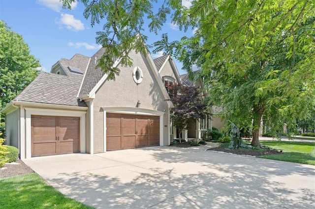 14605 Dearborn St, Overland Park, KS 66223 - view of front of house with stucco siding, an attached garage, concrete driveway, and a shingled roof