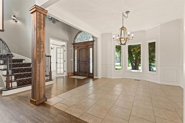 14605 Dearborn St, Overland Park, KS 66223 - foyer entrance with ornamental molding, a chandelier, stairs, a decorative wall, and wood finished floors