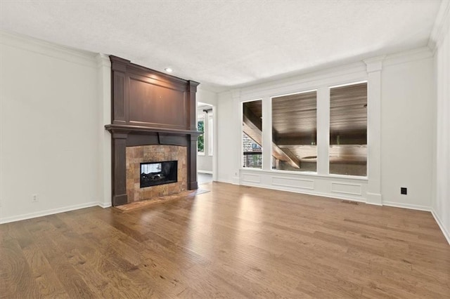 14605 Dearborn St, Overland Park, KS 66223 - unfurnished living room with wood finished floors, a tile fireplace, and a textured ceiling