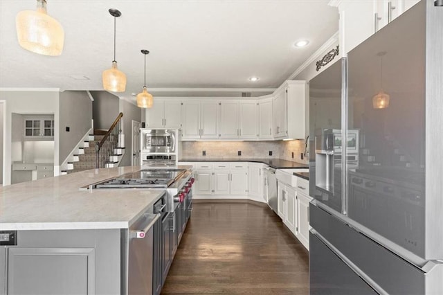 14605 Dearborn St, Overland Park, KS 66223 - kitchen featuring appliances with stainless steel finishes, dark wood-type flooring, white cabinetry, recessed lighting, and decorative backsplash