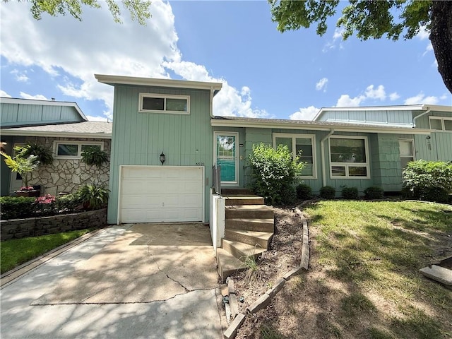 6521 W 49th St, Mission, KS 66202 - view of front facade with a garage, driveway, a front lawn, and board and batten siding
