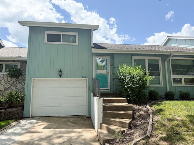 6521 W 49th St, Mission, KS 66202 - tri-level home featuring a garage, roof with shingles, and concrete driveway