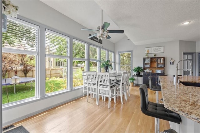 14105 W 115th St, Olathe, KS 66062 - sunroom featuring a sink, wood finished floors, plenty of natural light, a textured ceiling, and lofted ceiling