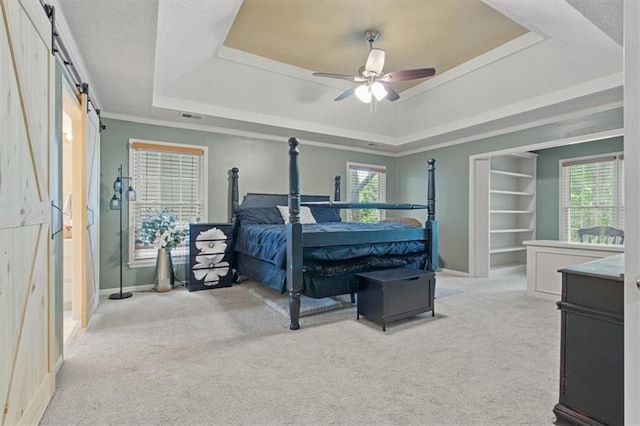 14105 W 115th St, Olathe, KS 66062 - carpeted bedroom featuring a raised ceiling, baseboards, ceiling fan, a barn door, and ornamental molding