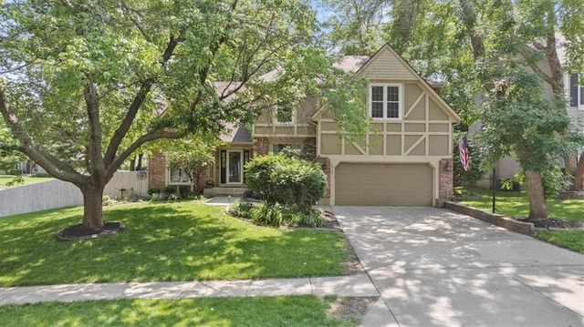14105 W 115th St, Olathe, KS 66062 - tudor house with driveway, a front yard, a garage, and stucco siding