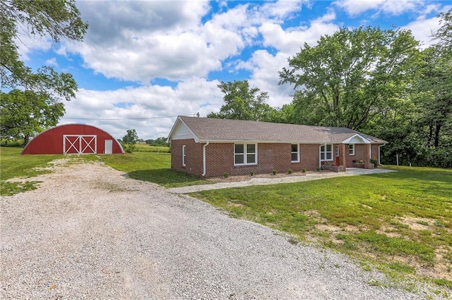 1129 US Highway 50, Centerview, MO 64019 - view of front facade with a barn, gravel driveway, brick siding, an outdoor structure, and a front lawn