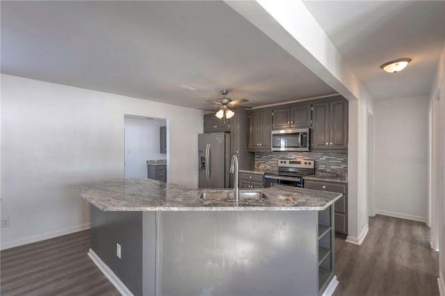 1129 US Highway 50, Centerview, MO 64019 - kitchen featuring appliances with stainless steel finishes, decorative backsplash, dark wood-style flooring, and a ceiling fan