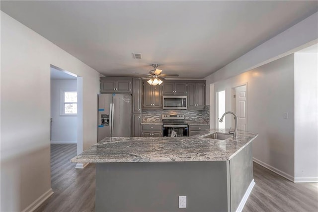 1129 US Highway 50, Centerview, MO 64019 - kitchen with appliances with stainless steel finishes, dark wood-style floors, a ceiling fan, and tasteful backsplash