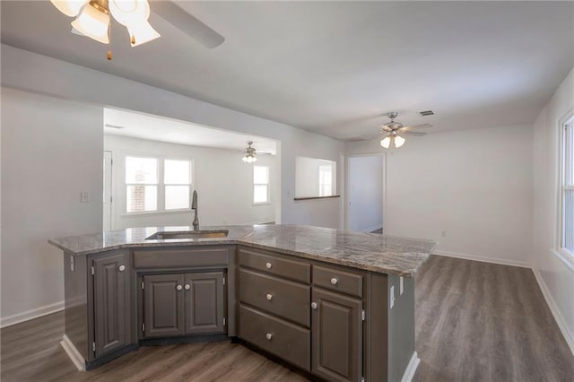 1129 US Highway 50, Centerview, MO 64019 - kitchen with a ceiling fan, open floor plan, dark wood-type flooring, and light stone countertops
