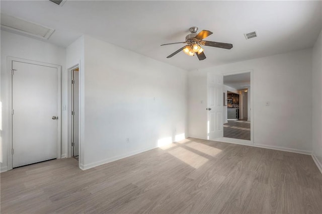 1129 US Highway 50, Centerview, MO 64019 - empty room featuring light wood-style flooring, a ceiling fan, and attic access