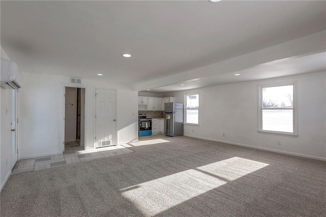 1129 US Highway 50, Centerview, MO 64019 - unfurnished living room with recessed lighting, light colored carpet, and a wall mounted air conditioner