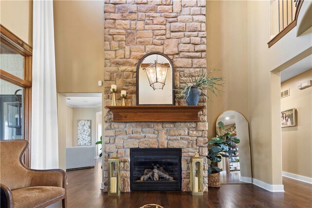 20711 Benson St, Bucyrus, KS 66013 - living room featuring wood finished floors, a high ceiling, plenty of natural light, and a stone fireplace