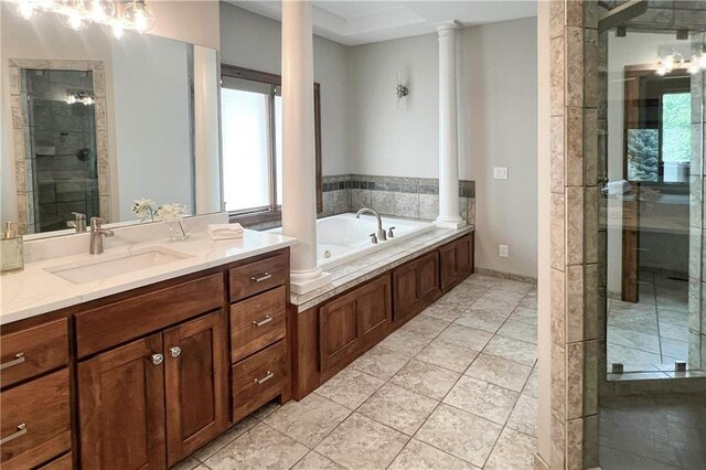 20711 Benson St, Bucyrus, KS 66013 - full bathroom with decorative columns, vanity, a tub with jets, a shower stall, and tile patterned flooring