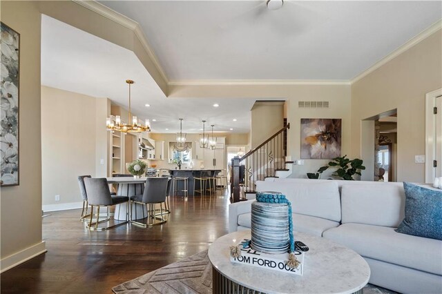 20711 Benson St, Bucyrus, KS 66013 - living area featuring a chandelier, ornamental molding, dark wood-style floors, and stairs