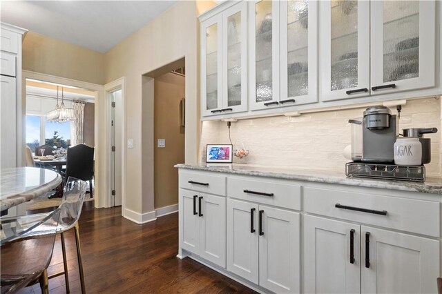20711 Benson St, Bucyrus, KS 66013 - bar with a chandelier, dark wood-type flooring, and backsplash