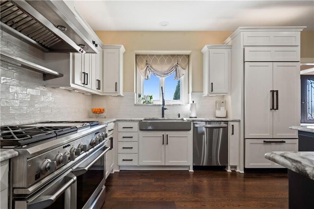 20711 Benson St, Bucyrus, KS 66013 - kitchen with appliances with stainless steel finishes, range hood, white cabinetry, light stone countertops, and dark wood-style floors