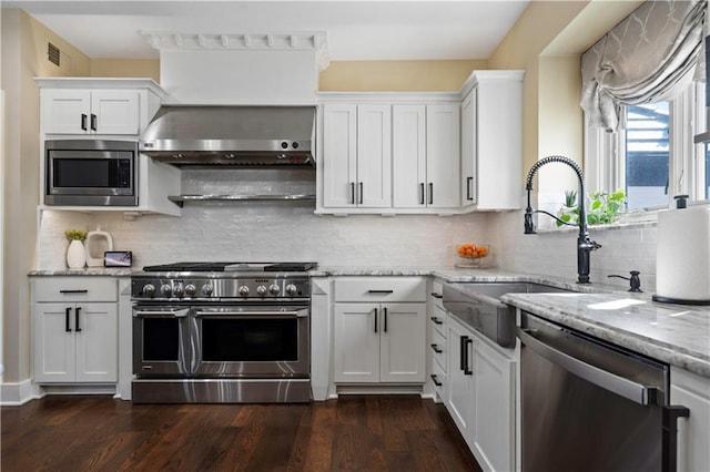 20711 Benson St, Bucyrus, KS 66013 - kitchen with appliances with stainless steel finishes, white cabinetry, light stone countertops, dark wood-style flooring, and backsplash