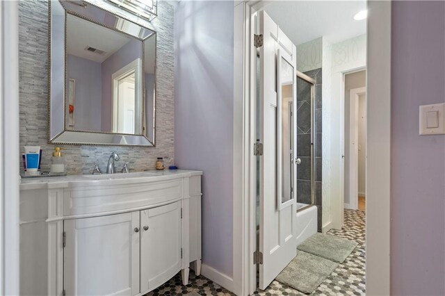 20711 Benson St, Bucyrus, KS 66013 - bathroom featuring vanity, decorative backsplash, bath / shower combo with glass door, and tile patterned floors