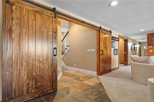 20711 Benson St, Bucyrus, KS 66013 - hallway featuring a barn door, a textured ceiling, recessed lighting, and stairs