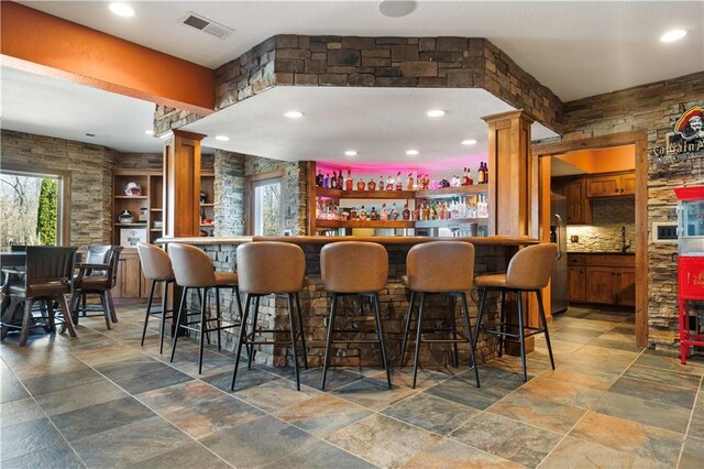 20711 Benson St, Bucyrus, KS 66013 - indoor bar featuring plenty of natural light, decorative columns, stone tile floors, and recessed lighting