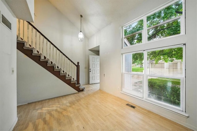 11431 Reeder St, Overland Park, KS 66210 - foyer with wood finished floors, high vaulted ceiling, and stairway