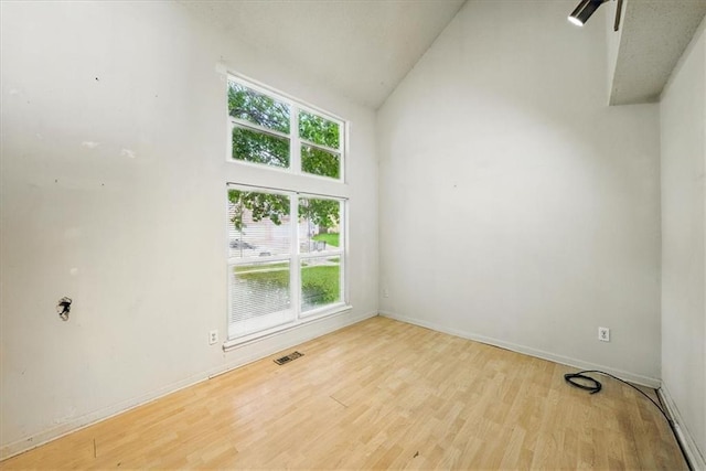 11431 Reeder St, Overland Park, KS 66210 - spare room featuring wood finished floors, baseboards, and high vaulted ceiling