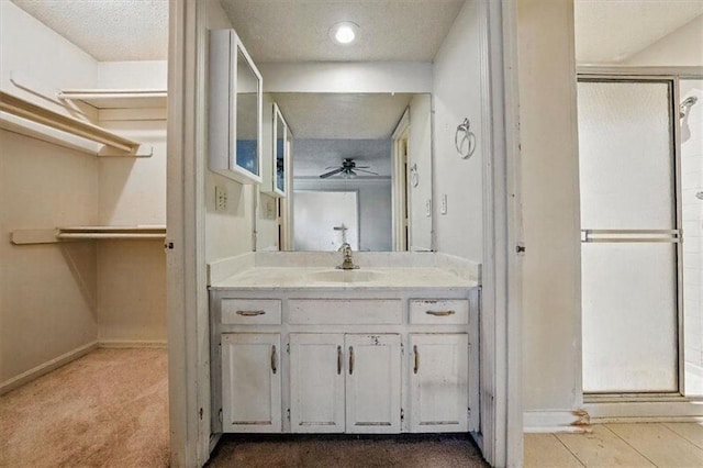 11431 Reeder St, Overland Park, KS 66210 - full bath with a shower stall, a ceiling fan, vanity, baseboards, and a textured ceiling