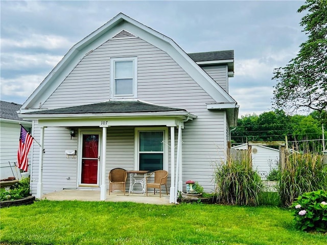107 W 23rd St, Higginsville, MO 64037 - view of front facade with a front yard, roof with shingles, and a gambrel roof