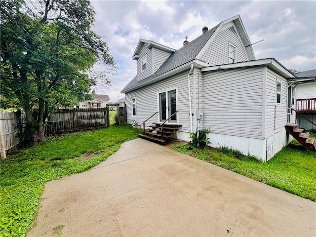 107 W 23rd St, Higginsville, MO 64037 - back of house featuring entry steps and roof with shingles