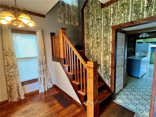 107 W 23rd St, Higginsville, MO 64037 - stairs with wood finished floors and a chandelier