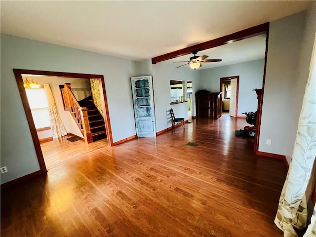 107 W 23rd St, Higginsville, MO 64037 - unfurnished living room featuring stairs, wood finished floors, and a ceiling fan
