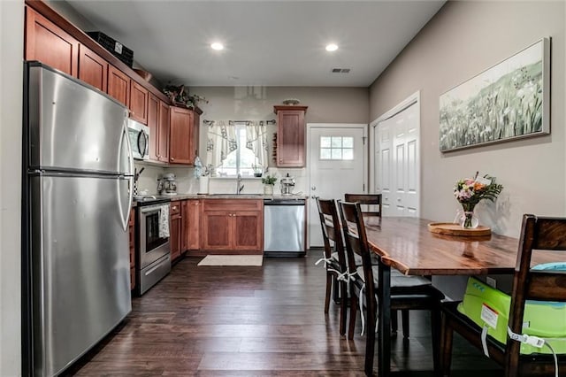 128 S Poplar St, Ottawa, KS 66067 - kitchen with stainless steel appliances, dark wood-style flooring, a sink, recessed lighting, and brown cabinetry