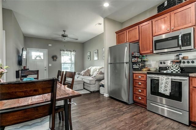 128 S Poplar St, Ottawa, KS 66067 - kitchen with stainless steel appliances, brown cabinets, open floor plan, dark wood-style floors, and a ceiling fan