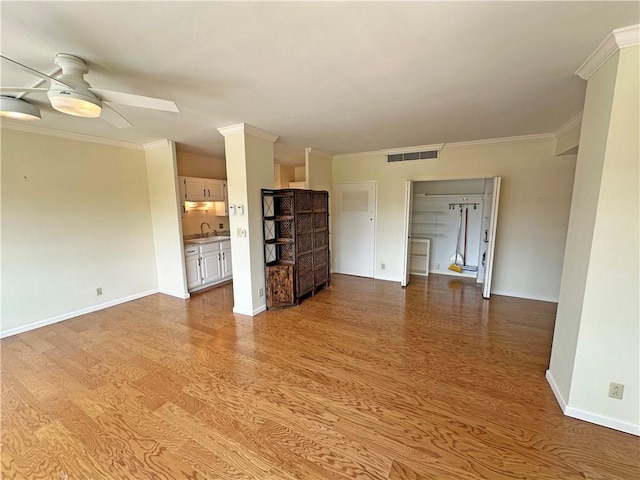 333 W Meyer Blvd Unit 414, Kansas City, MO 64113 - unfurnished living room with a sink, a ceiling fan, wood finished floors, baseboards, and crown molding