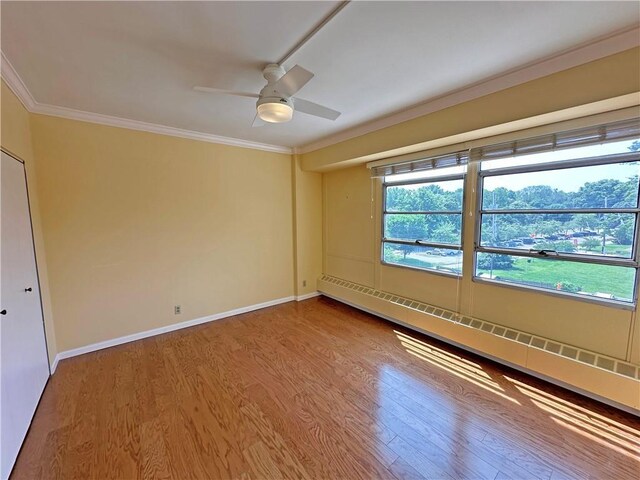 333 W Meyer Blvd Unit 414, Kansas City, MO 64113 - spare room featuring wood finished floors, ornamental molding, a baseboard radiator, ceiling fan, and baseboards