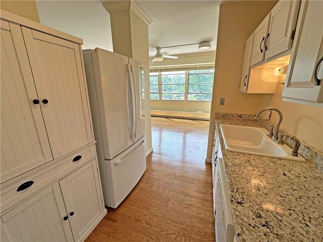 333 W Meyer Blvd Unit 414, Kansas City, MO 64113 - kitchen featuring freestanding refrigerator, a sink, light wood-style flooring, ceiling fan, and a baseboard heating unit