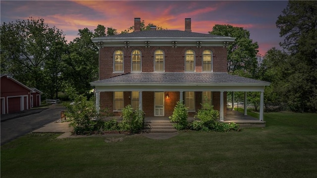 5322 SE Riverside Ter, Saint Joseph, MO 64507 - italianate house featuring covered porch, brick siding, a chimney, and a yard