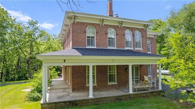 5322 SE Riverside Ter, Saint Joseph, MO 64507 - rear view of property with a chimney, brick siding, a lawn, and a shingled roof