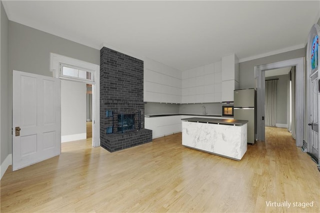 5322 SE Riverside Ter, Saint Joseph, MO 64507 - kitchen featuring freestanding refrigerator, a center island, light wood-type flooring, and white cabinetry
