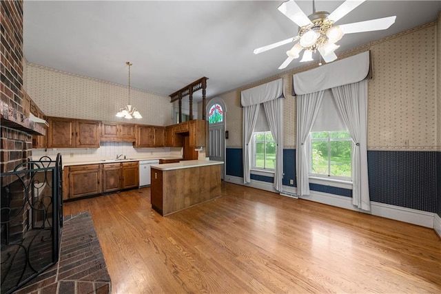 5322 SE Riverside Ter, Saint Joseph, MO 64507 - kitchen with wallpapered walls, dishwasher, brown cabinets, wood finished floors, and light countertops