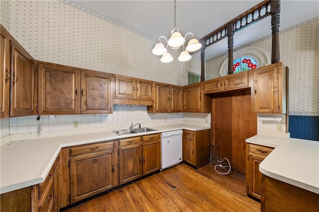 5322 SE Riverside Ter, Saint Joseph, MO 64507 - kitchen featuring dishwasher, wallpapered walls, wood finished floors, a sink, and a chandelier