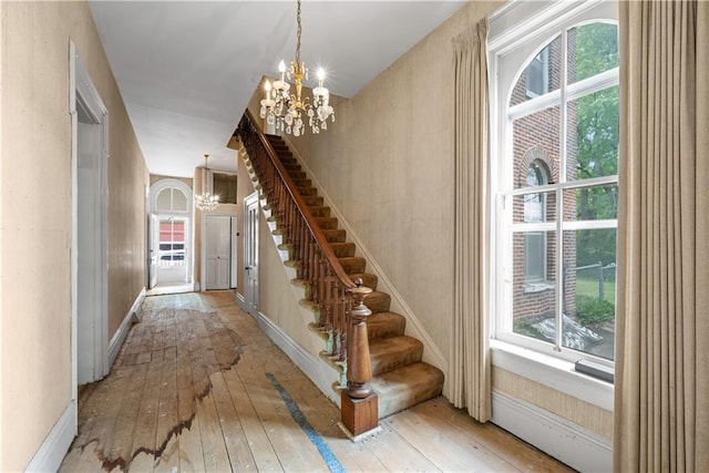 5322 SE Riverside Ter, Saint Joseph, MO 64507 - stairs featuring a chandelier, hardwood / wood-style floors, and plenty of natural light