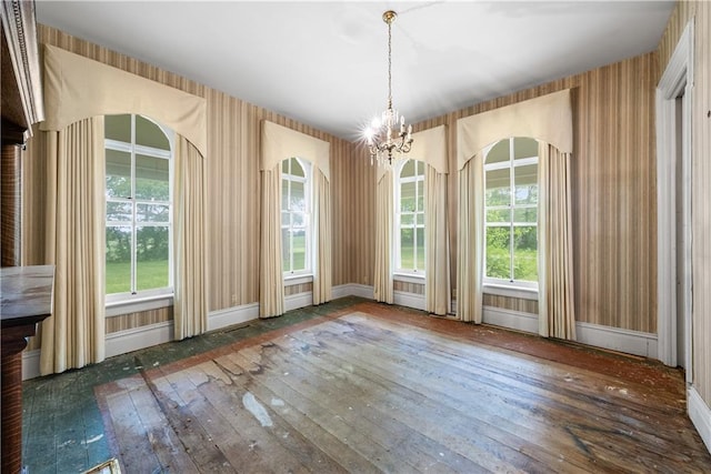 5322 SE Riverside Ter, Saint Joseph, MO 64507 - unfurnished dining area featuring hardwood / wood-style floors, a chandelier, plenty of natural light, and baseboards