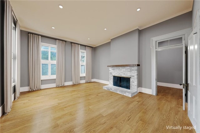5322 SE Riverside Ter, Saint Joseph, MO 64507 - unfurnished living room with ornamental molding, a brick fireplace, light wood-style flooring, recessed lighting, and baseboards