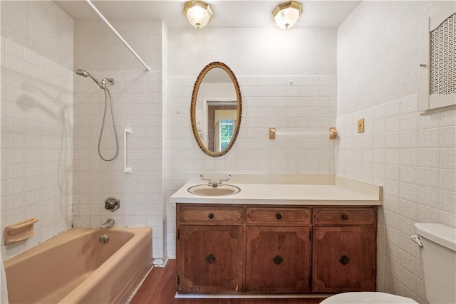 5322 SE Riverside Ter, Saint Joseph, MO 64507 - bathroom featuring tile walls, toilet,  shower combination, vanity, and wood finished floors