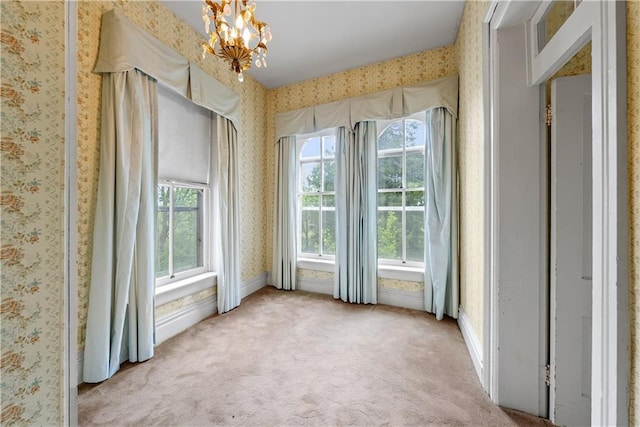 5322 SE Riverside Ter, Saint Joseph, MO 64507 - empty room with wallpapered walls, light colored carpet, and a chandelier