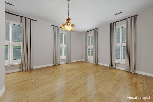 5322 SE Riverside Ter, Saint Joseph, MO 64507 - spare room with a chandelier, wood finished floors, and baseboards
