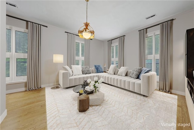 5322 SE Riverside Ter, Saint Joseph, MO 64507 - living area featuring a chandelier, light wood-style floors, and baseboards
