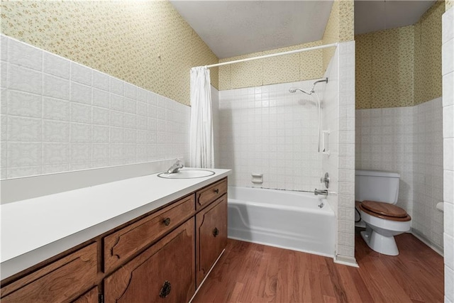 5322 SE Riverside Ter, Saint Joseph, MO 64507 - bathroom featuring wallpapered walls, wood finished floors, shower / tub combo, toilet, and tile walls